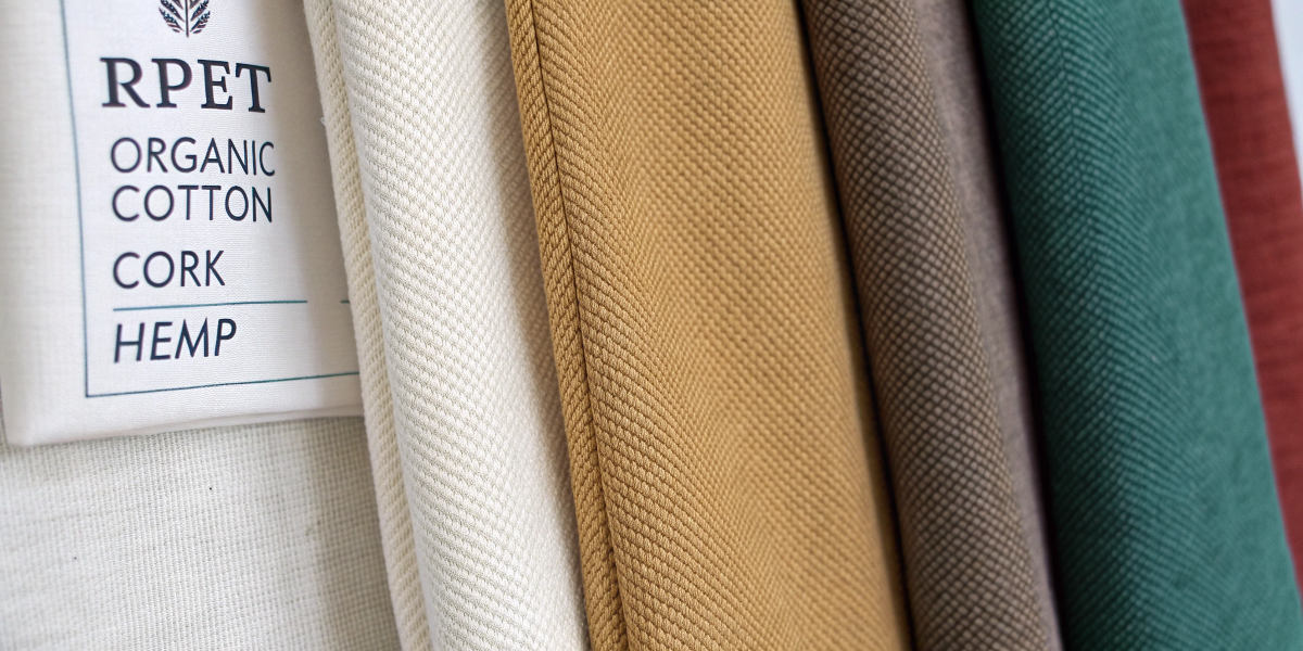 Fabric swatches of top eco-friendly materials like RPET, organic cotton, cork, and hemp